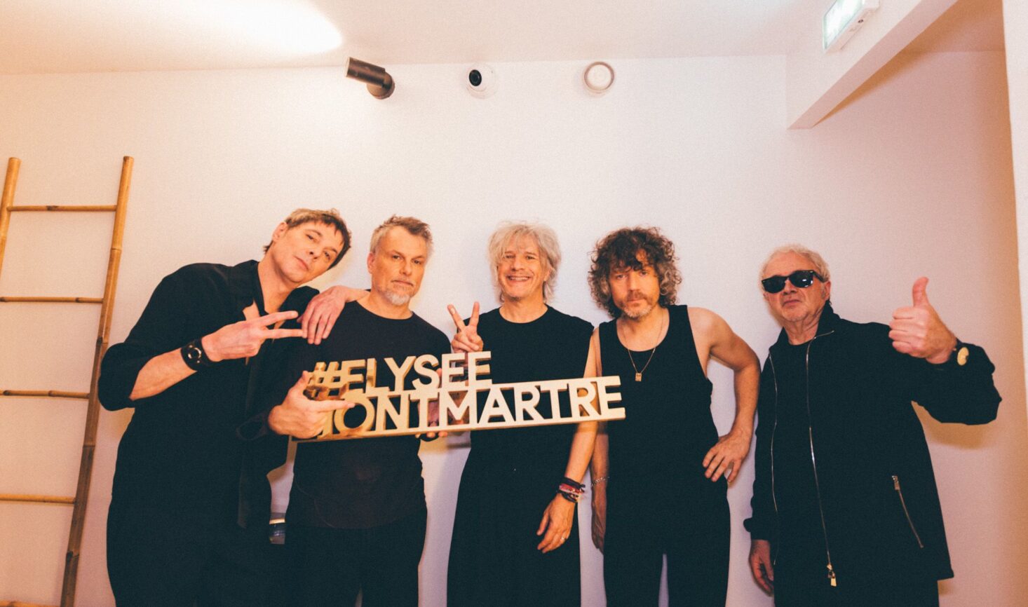 Le groupe Indochine avec le chanteur principal Nicolas Sirkis posent avec le hashtag Élysée Montmartre lors de leur concert le 9 décembre 2024 dans la salle de concert Élysée Montmartre.